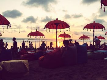 Group of people sitting against sky during sunset