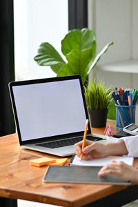 Cropped hands of woman writing in diary