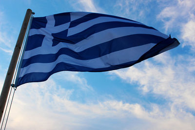 Low angle view of flag against blue sky