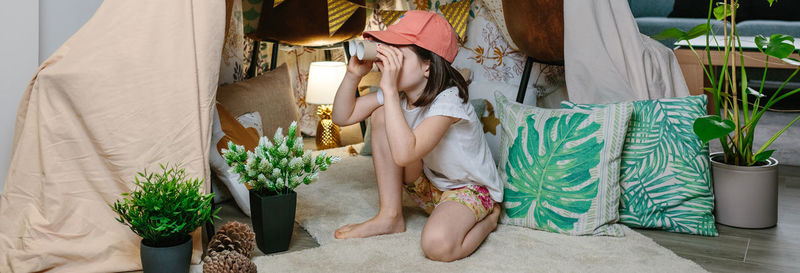 Woman sitting by potted plant