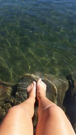 Low section of woman over sea