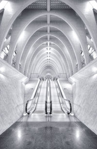 Rear view of man walking in illuminated tunnel