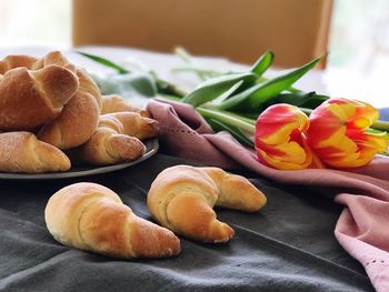 Close-up of bread and tulips on table