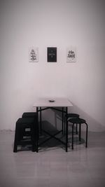 Empty chairs and table against wall at home