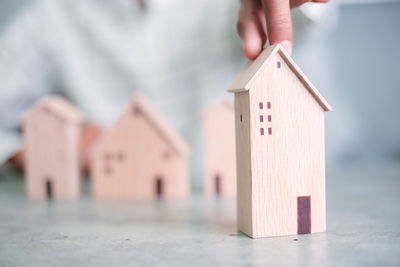 Close-up of hand with toy on house in building