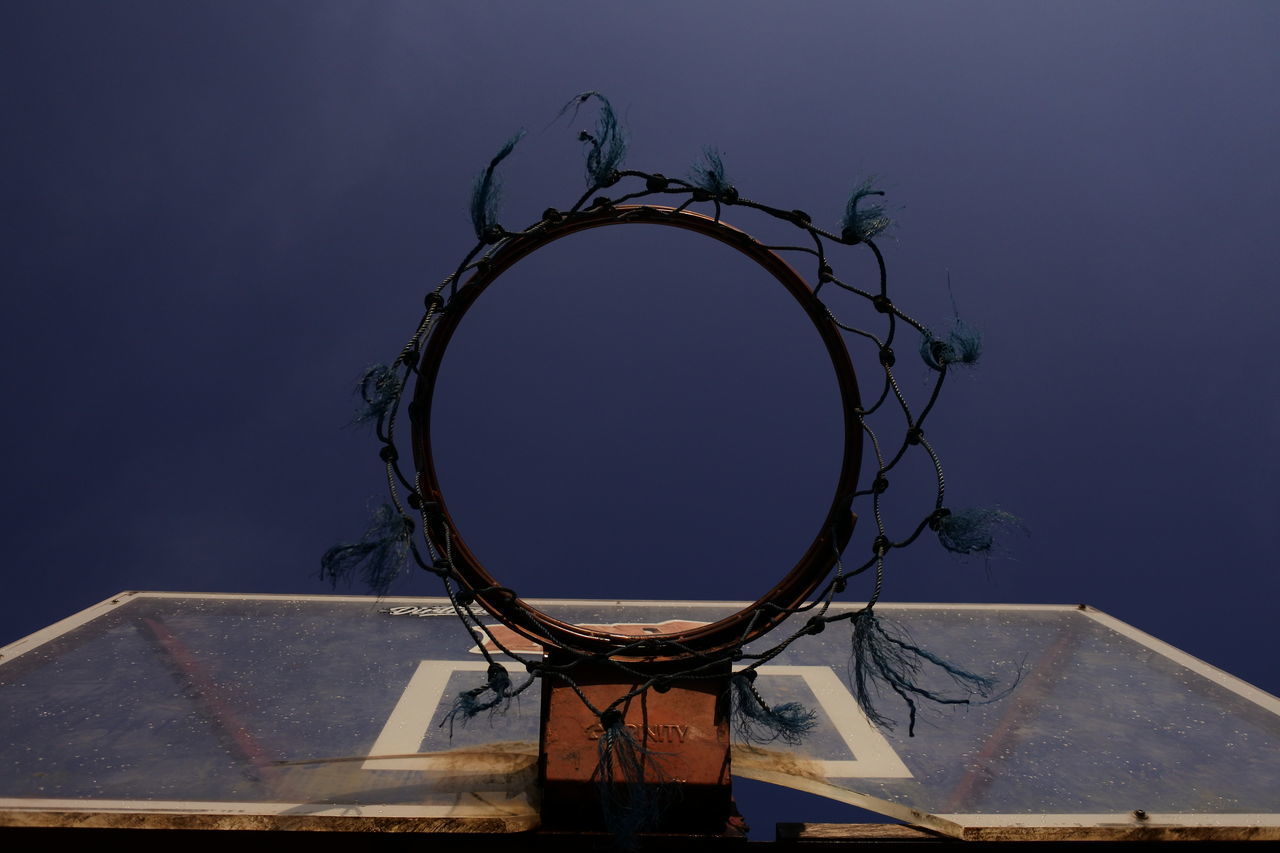 LOW ANGLE VIEW OF BASKETBALL HOOP AGAINST CLEAR BLUE SKY