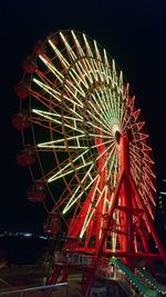 Low angle view of illuminated ferris wheel against sky at night