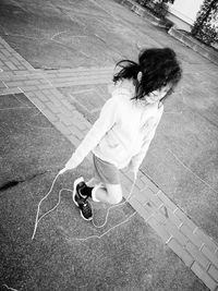 Girl skipping on footpath