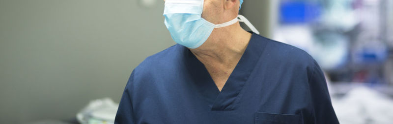 Midsection of senior man wearing surgical mask