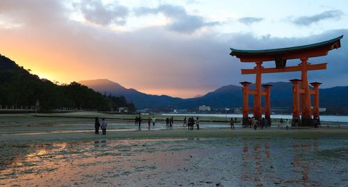 Tourists on mountain at sunset