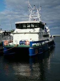 Ship moored at harbor against sky