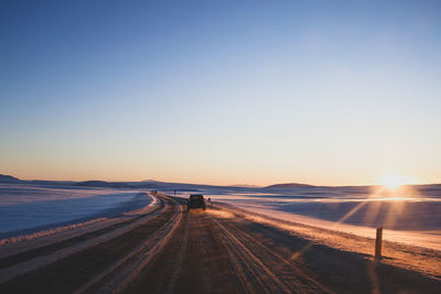 Scenic view of road against clear sky during sunset