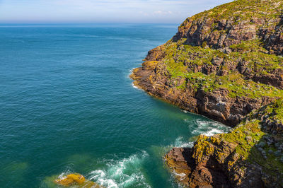 High angle view of rocks by sea against sky