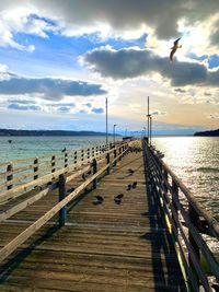 Pier over sea against sky during sunset