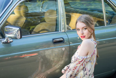 Portrait of woman by car