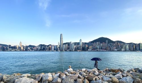 Sea by buildings against sky