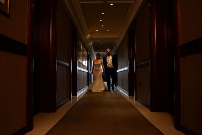 Well dressed bride and groom walking in corridor