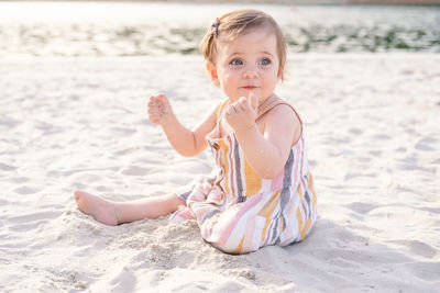 Portrait of cute girl sitting on beach