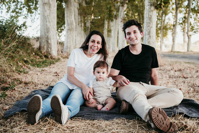 Full length of father and son sitting in park