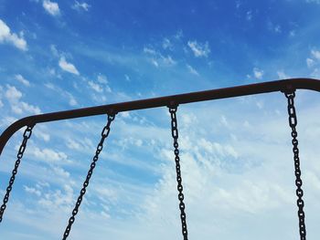 Metal chain of swings against sky