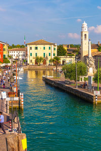 Canal amidst buildings in city against sky