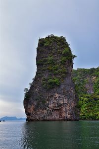 Rock formations by sea against sky