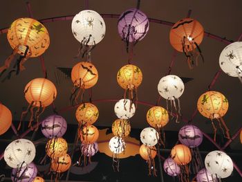 Illuminated lanterns hanging against ceiling