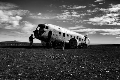 Abandoned airplane on field against sky