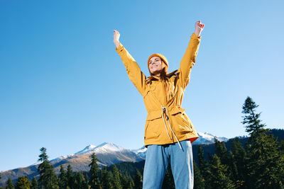 Rear view of woman standing against mountain