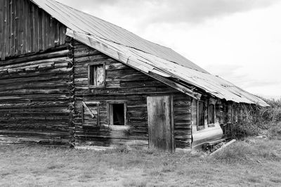 Old abandoned house on landscape against sky