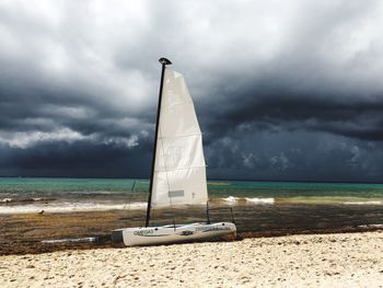 Sailboat on beach against sky