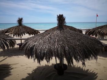 Panoramic view of beach umbrellas by sea against sky