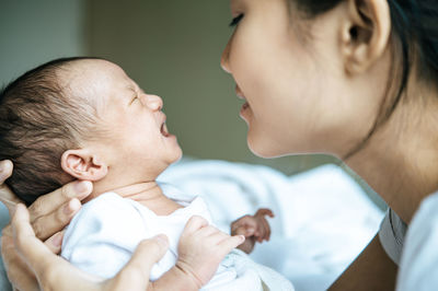 Close-up of mother holding baby at home