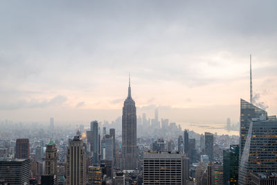 Buildings in city against cloudy sky