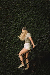 Side view of woman standing against plants