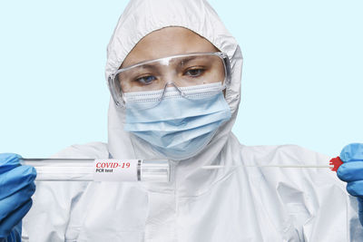 Portrait of doctor wearing protective mask against white background