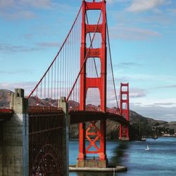 Low angle view of suspension bridge against sky