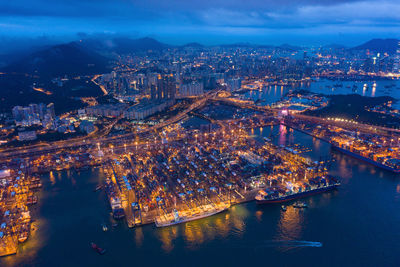 High angle view of illuminated city by river at night