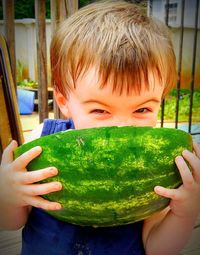 Close-up portrait of boy holding watermelon