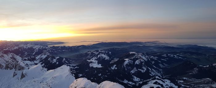 Scenic view of snowcapped mountains against sky during sunset