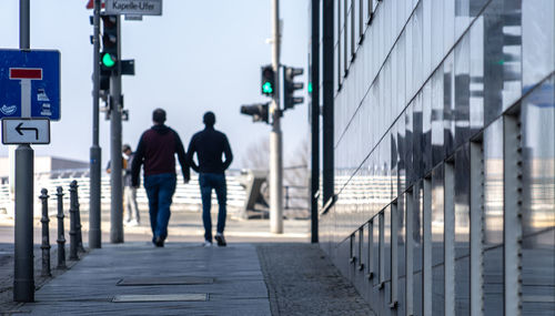 Rear view of people walking on footpath