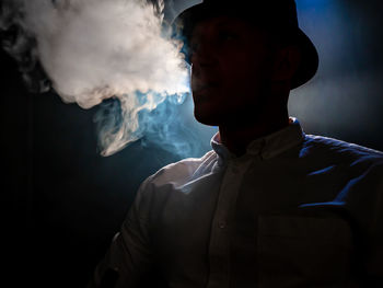 Portrait of young man against dark background