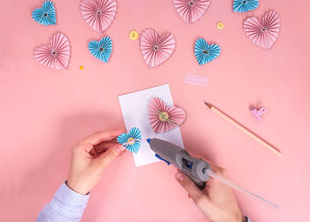 Midsection of woman holding paper flowers