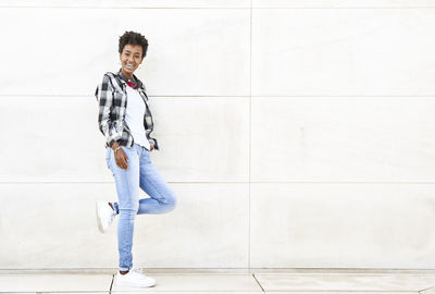 Portrait of young man standing against wall