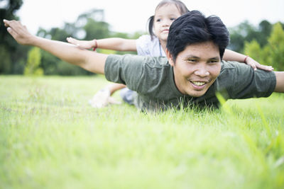 Portrait of young woman playing with ball on grass