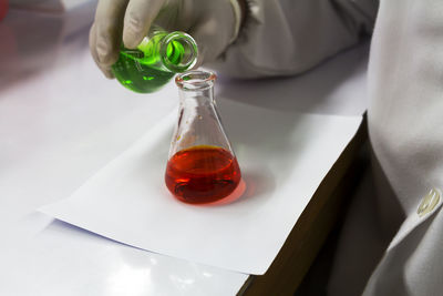 Close-up of hand holding laboratory glassware