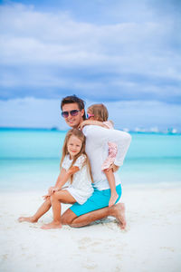 Woman wearing sunglasses on beach against sky