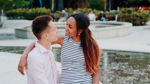 Smiling couple standing against building terrace