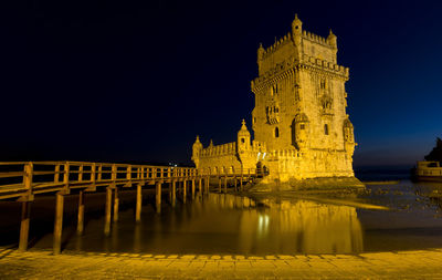 Reflection of illuminated building in water at night