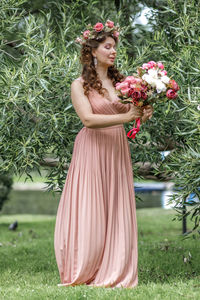 Portrait of young woman standing amidst plants